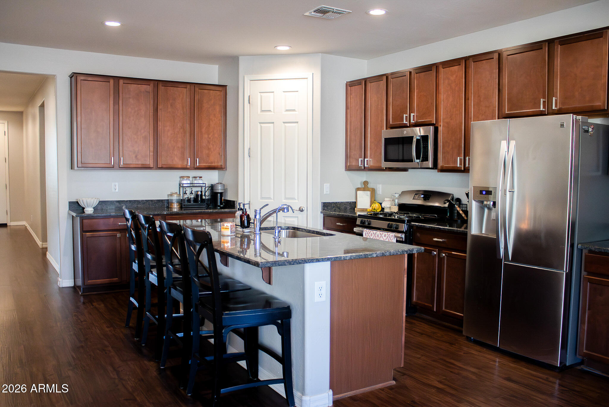 20378 West Maiden Lane Buckeye, AZ 85396 - Photo 16 of 41 a kitchen with stainless steel appliances a table chairs refrigerator and microwave