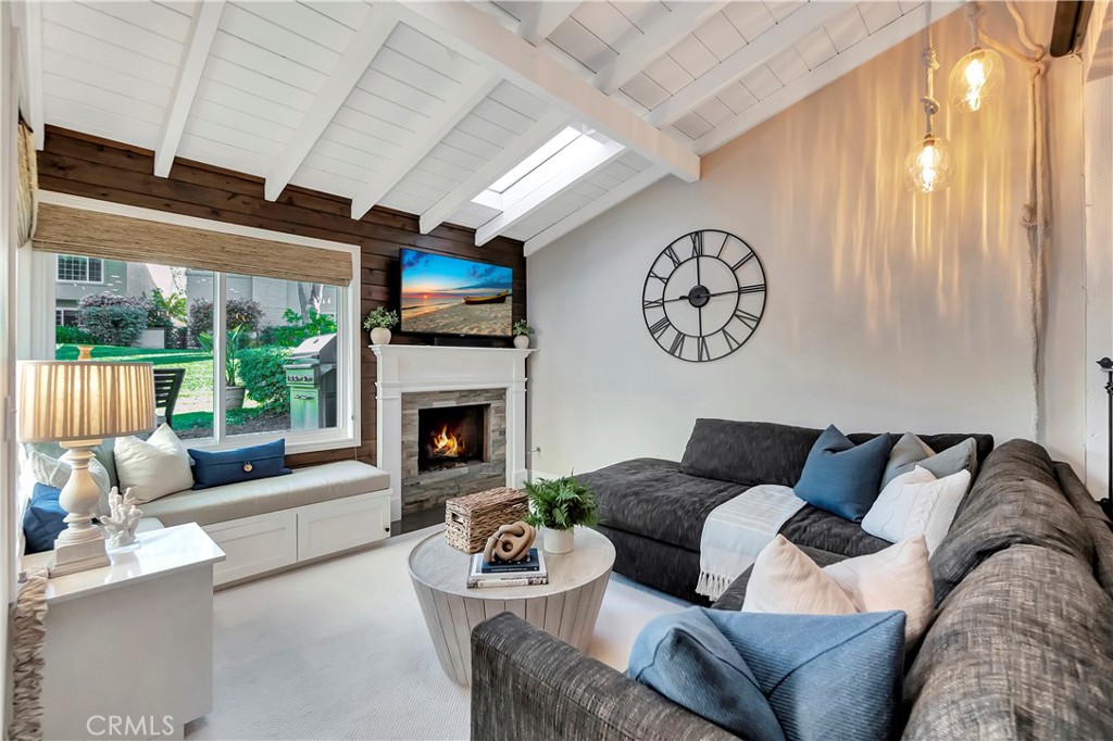 507 Cancha Newport Beach, CA 92660 - Photo 21 of 39 a living room with furniture a fireplace and a large window with garden view