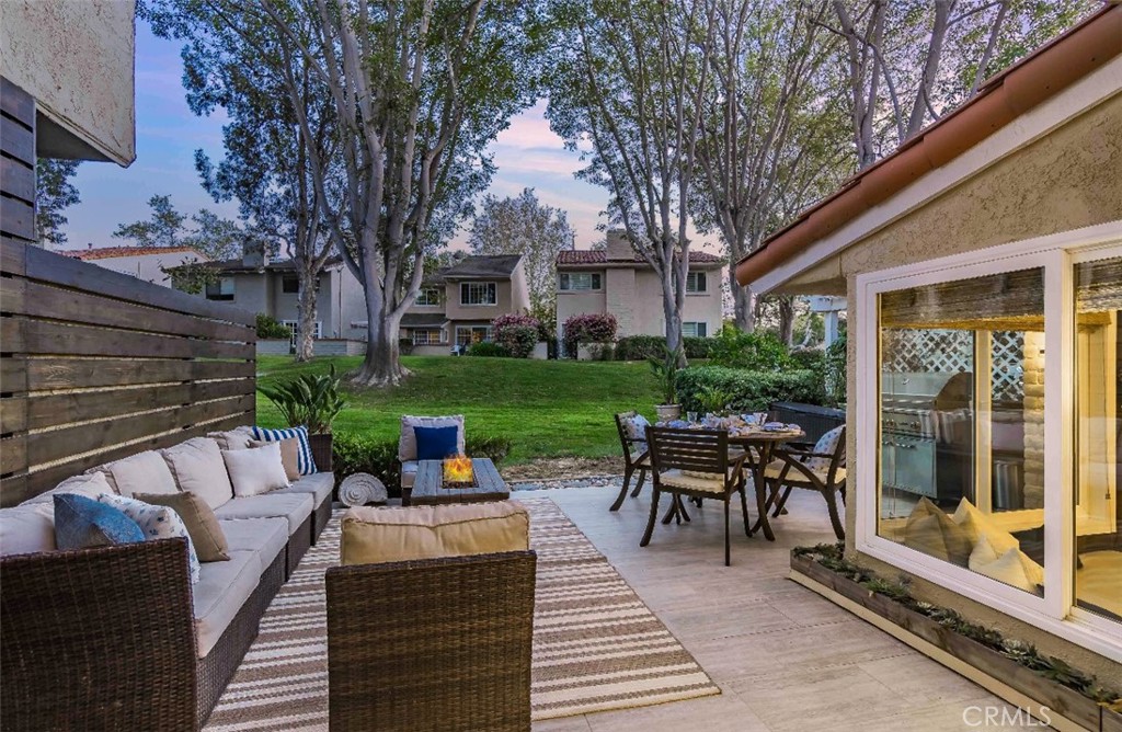 507 Cancha Newport Beach, CA 92660 - Photo 35 of 39 a view of a patio with table and chairs potted plants and a large tree