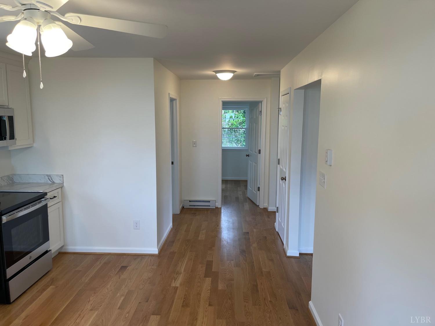 145 Church Street Amherst, VA 24521 - Photo 12 of 23 a view of a hallway with wooden floor and a fireplace