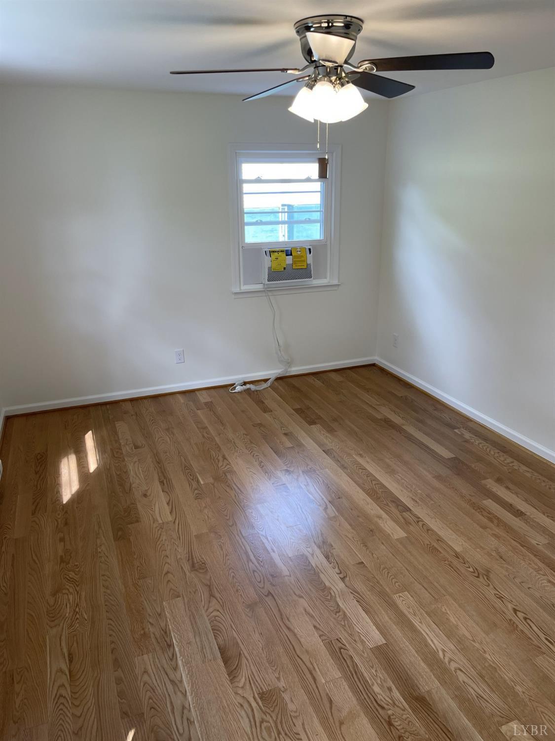 145 Church Street Amherst, VA 24521 - Photo 4 of 23 wooden floor in an empty room with a window