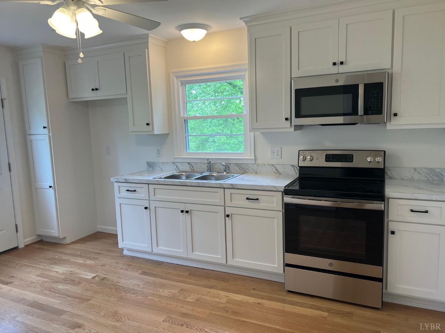 145 Church Street Amherst, VA 24521 - Photo 6 of 23 a kitchen with granite countertop white cabinets stainless steel appliances and a window