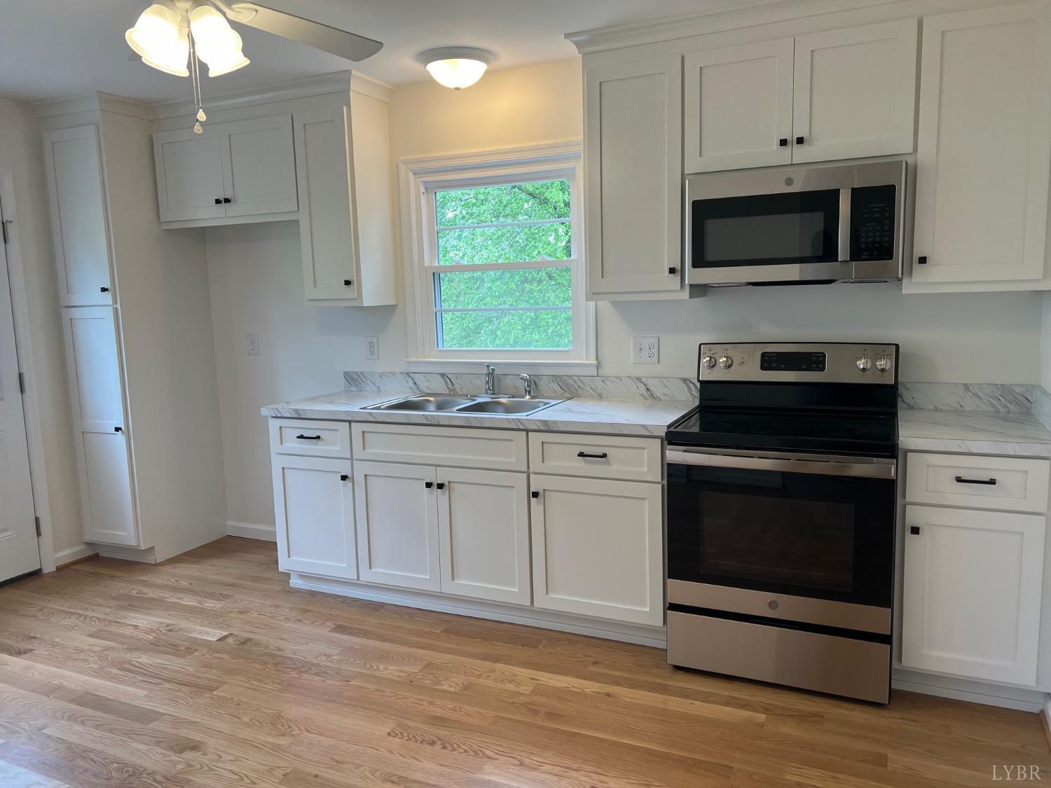 145 Church Street Amherst, VA 24521 - Photo 9 of 23 a kitchen with granite countertop white cabinets stainless steel appliances and a window