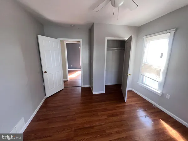 an empty room with wooden floor and a window