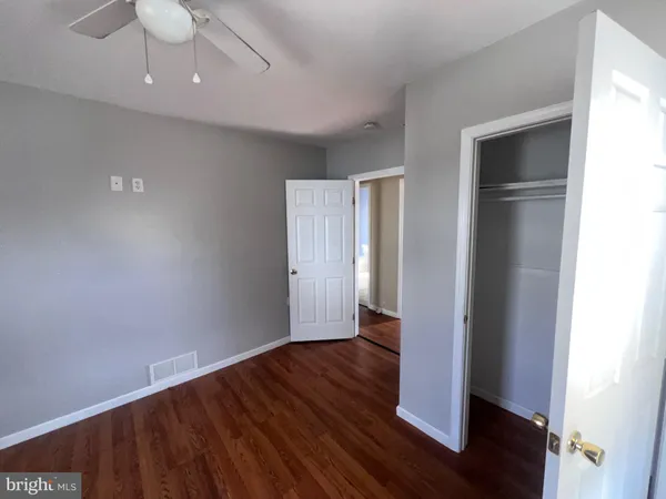 an empty room with wooden floor and closet