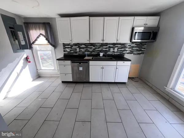 a kitchen with stainless steel appliances a stove a sink and a microwave