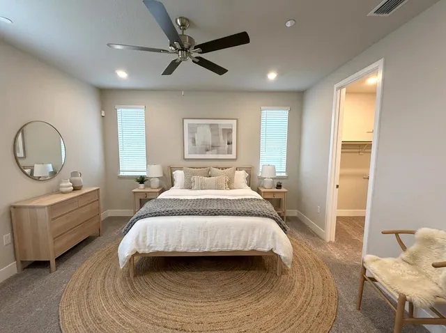 a spacious bedroom with a bed a window and a chandelier