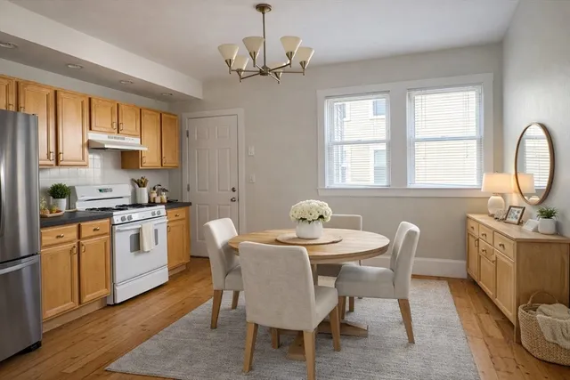 a kitchen with stainless steel appliances granite countertop a kitchen island hardwood floor sink stove dining table and chairs