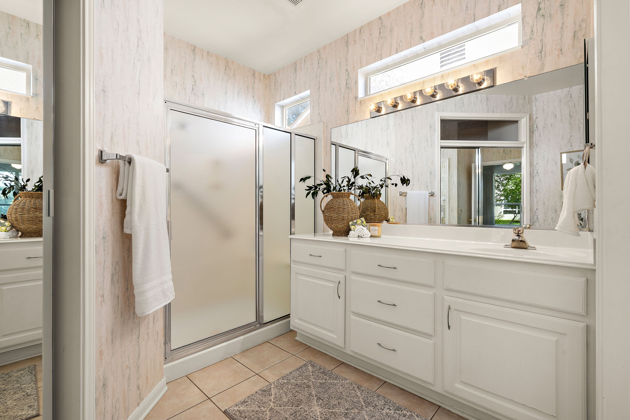 191 Trail Rider Way Georgetown, TX 78633 - Photo 15 of 25 Ample counter space and crisp white cabinetry define this primary bath, complete with a glass-enclosed shower.