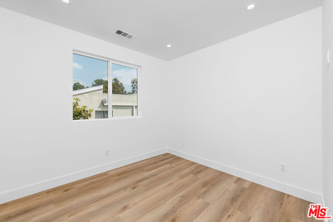 4337 Dixie Canyon Avenue Sherman Oaks, CA 91423 - Photo 12 of 22 a view of empty room with wooden floor and fan