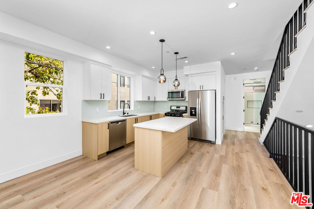 4337 Dixie Canyon Avenue Sherman Oaks, CA 91423 - Photo 3 of 22 a large kitchen with a lot of counter space wooden floor and stainless steel appliances