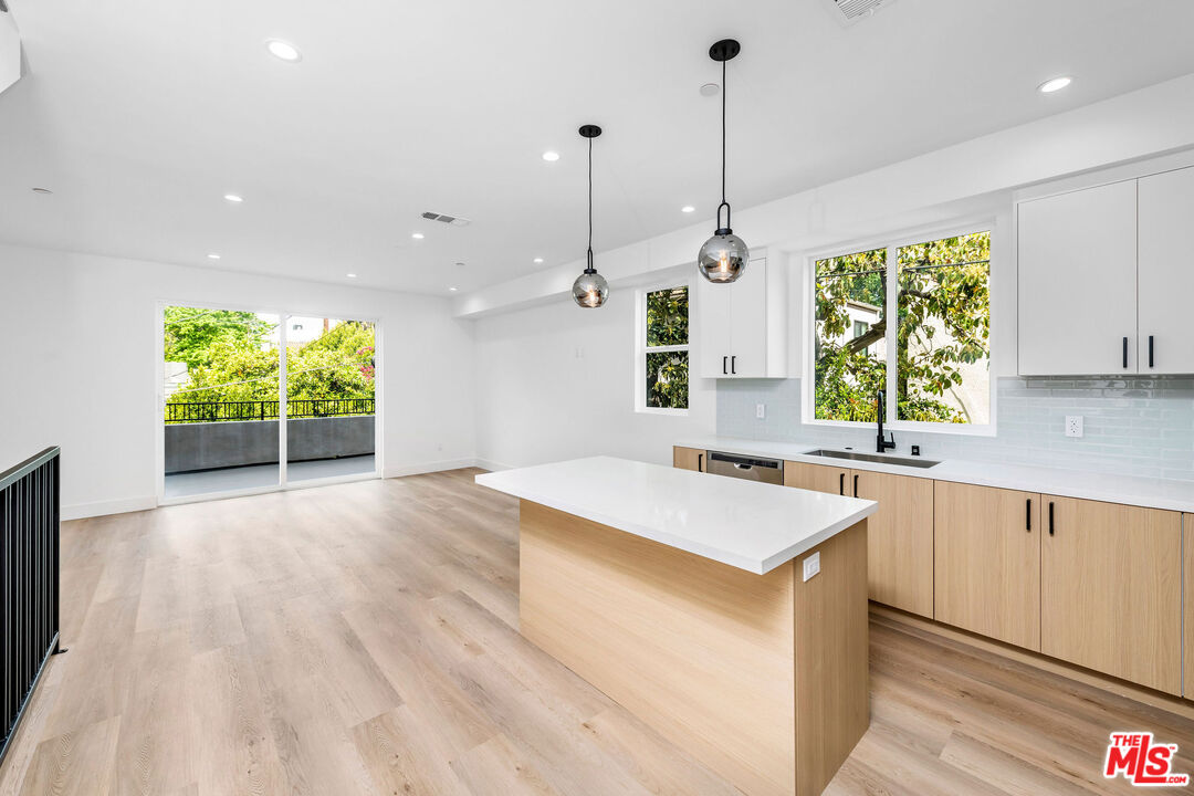 4337 Dixie Canyon Avenue Sherman Oaks, CA 91423 - Photo 4 of 22 a kitchen with a stove a sink a window and wooden floor