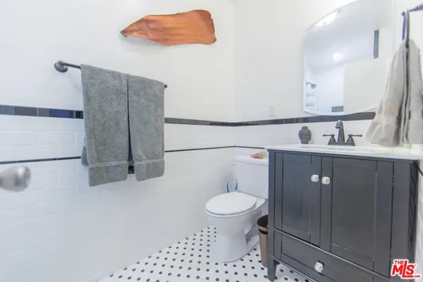 a bathroom with a sink a toilet and a mirror