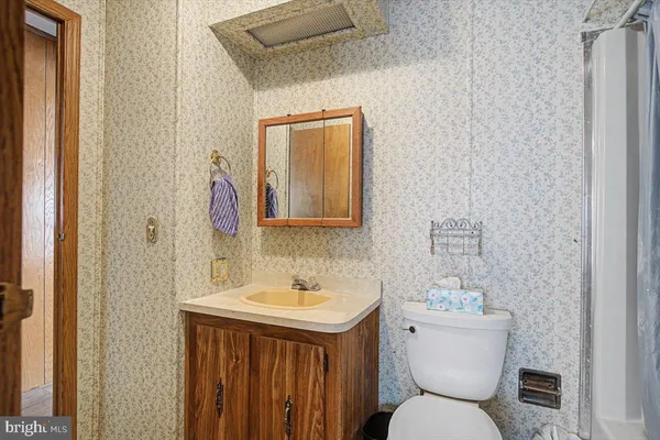 a bathroom with a toilet sink and mirror