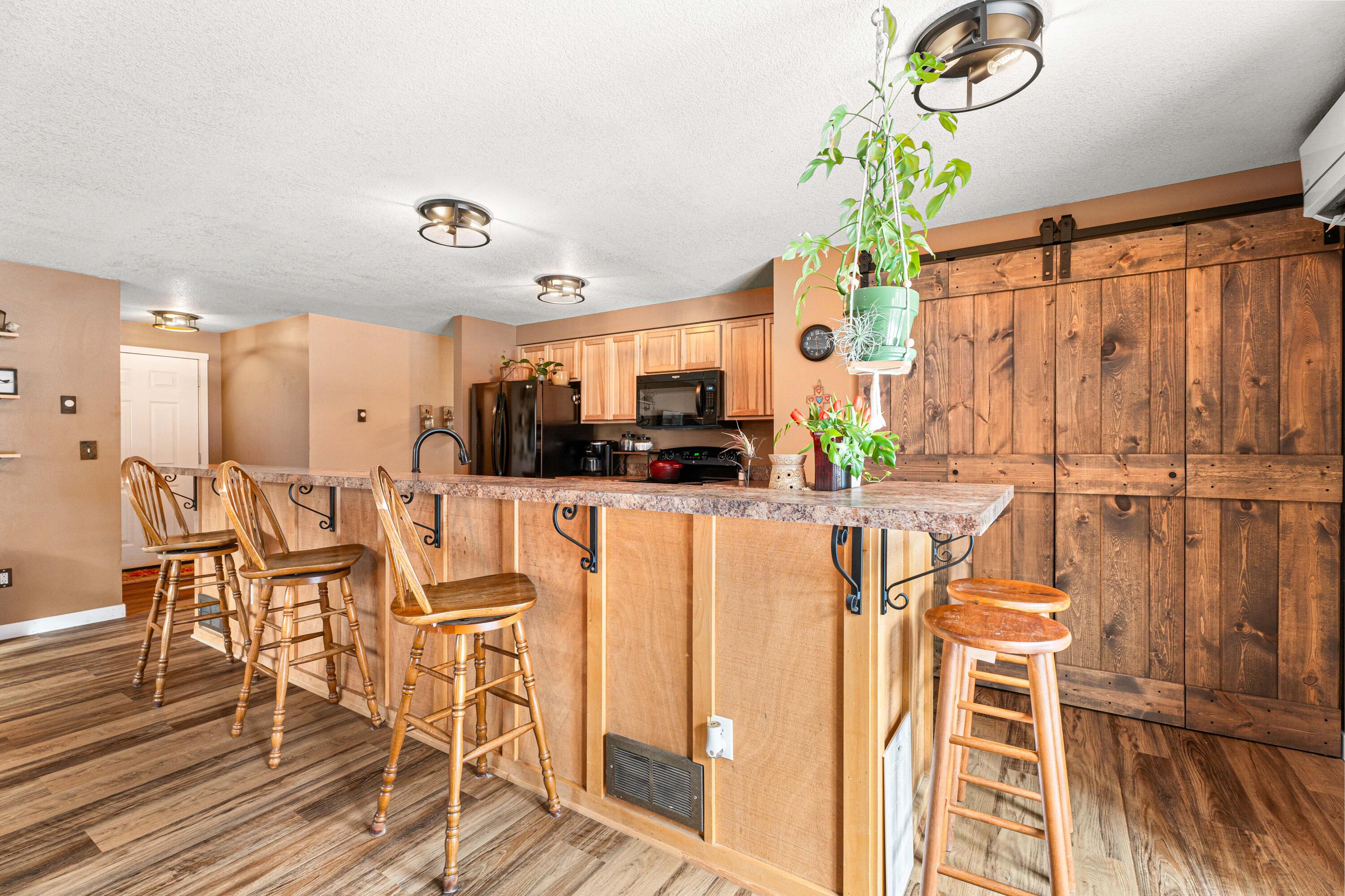 16939 Torrance Road Bend, OR 97707 - Photo 12 of 33 a view of a dining room with furniture a chandelier and wooden floor