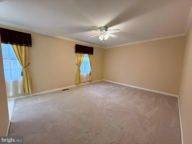 an empty room with a ceiling fan and a window