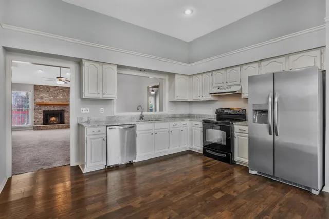 a kitchen with white cabinets and stainless steel appliances