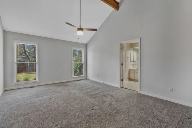 an empty room with windows and cabinet
