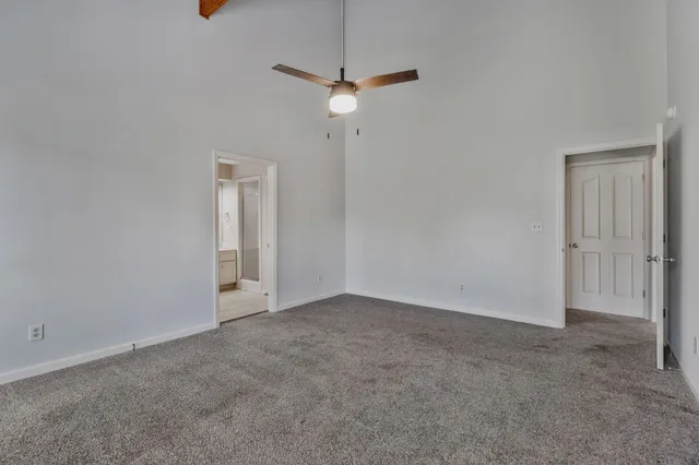 an empty room with a ceiling fan and window