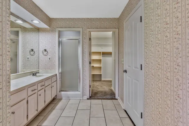 a bathroom with a granite countertop sink a mirror and a shower