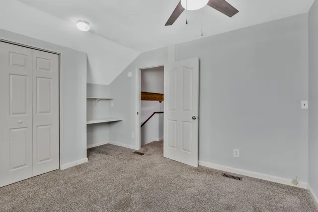 an empty room with a ceiling fan & entryway