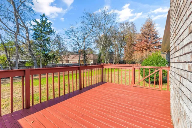 a view of wooden balcony and trees