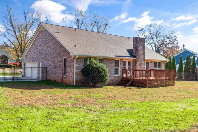 a view of a house with a yard and large tree