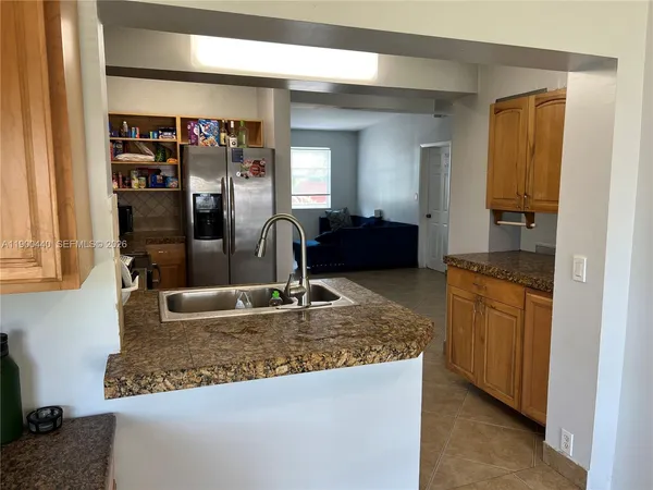 a kitchen with stainless steel appliances granite countertop a sink a refrigerator and a granite counter tops
