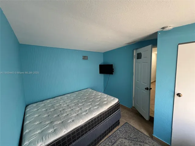 a bedroom with a bed and a tv
