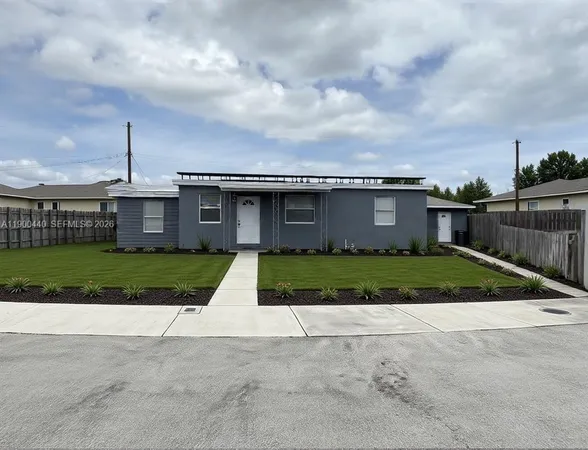 a front view of house with a garden