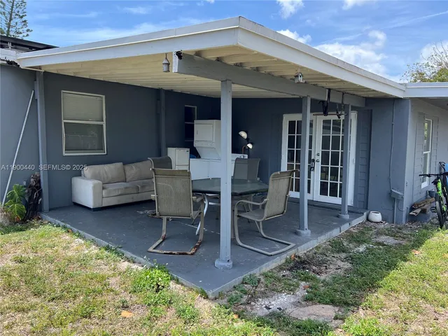 a view of a patio with table and chairs and potted plants