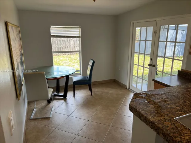 a bedroom with a bed a table and windows