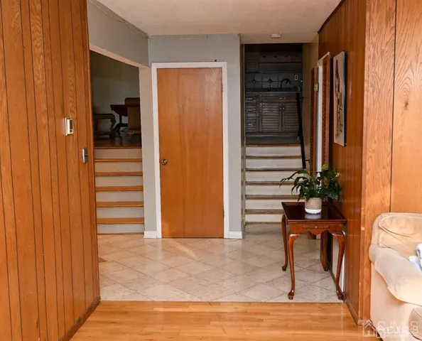 a view of a hallway with wooden floor and furniture