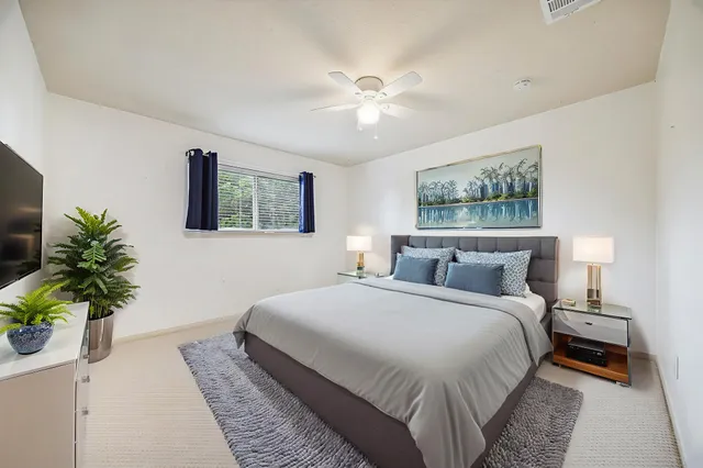 a bedroom with a large bed and a chandelier