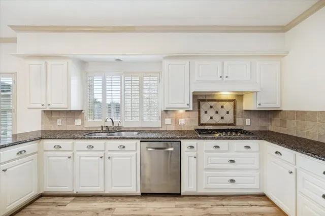 a kitchen with granite countertop white cabinets and white appliances