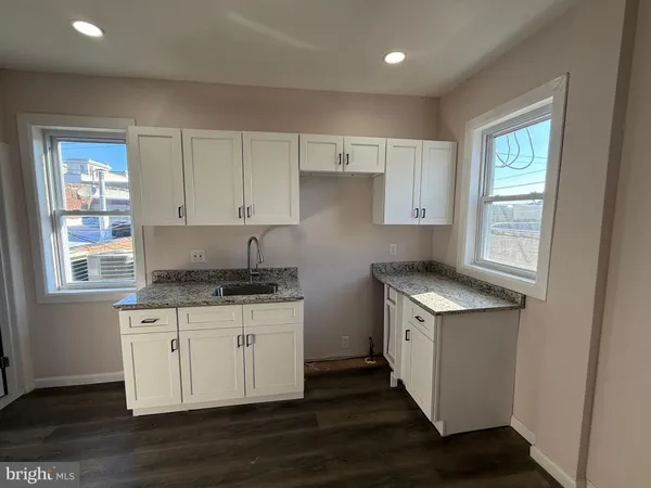 a kitchen with granite countertop a stove and a sink