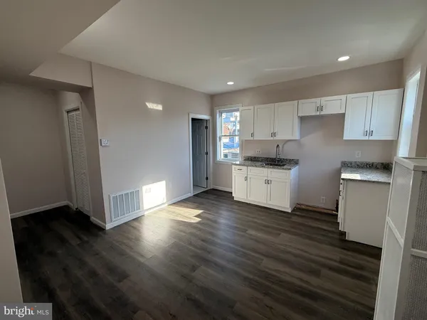 a kitchen with granite countertop a refrigerator and a stove top oven