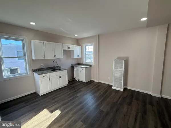 a kitchen with granite countertop a sink and cabinets