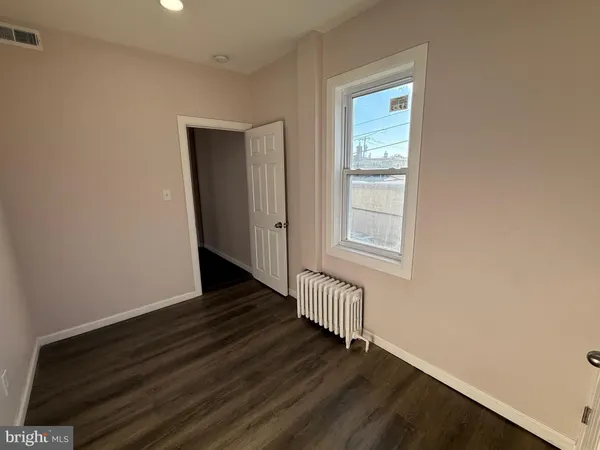 a view of a livingroom with wooden floor and window