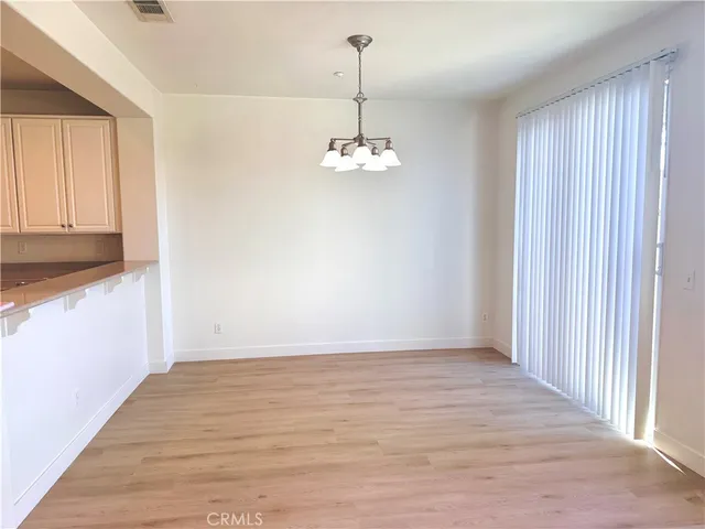 a view of a room with wooden floor and white walls