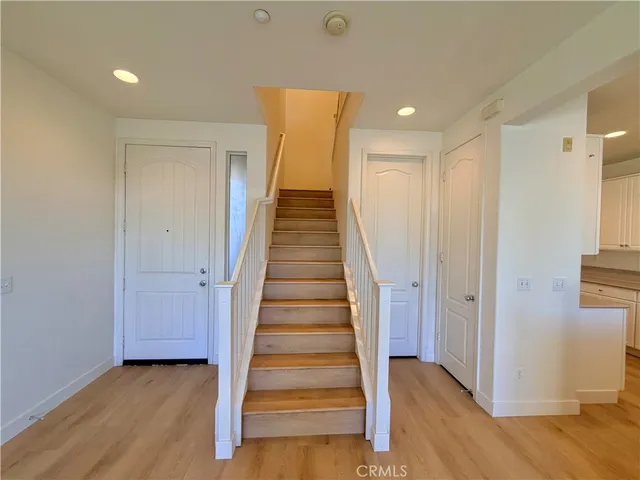 a view of a hallway with wooden floor and entryway