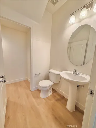 a bathroom with a toilet a sink and mirror