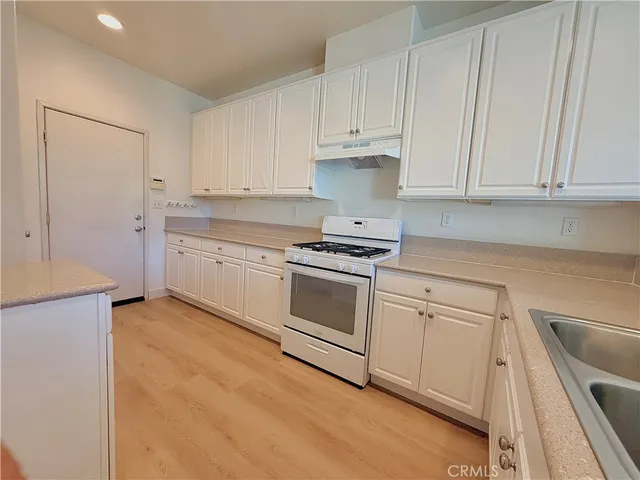 a kitchen with granite countertop white cabinets and white appliances