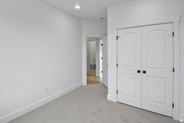 412 West 3025th Street South Logan, UT 84321 - Photo 24 of 34 Unfurnished bedroom with light carpet, a closet, and recessed lighting