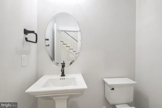a bathroom with a toilet sink and mirror