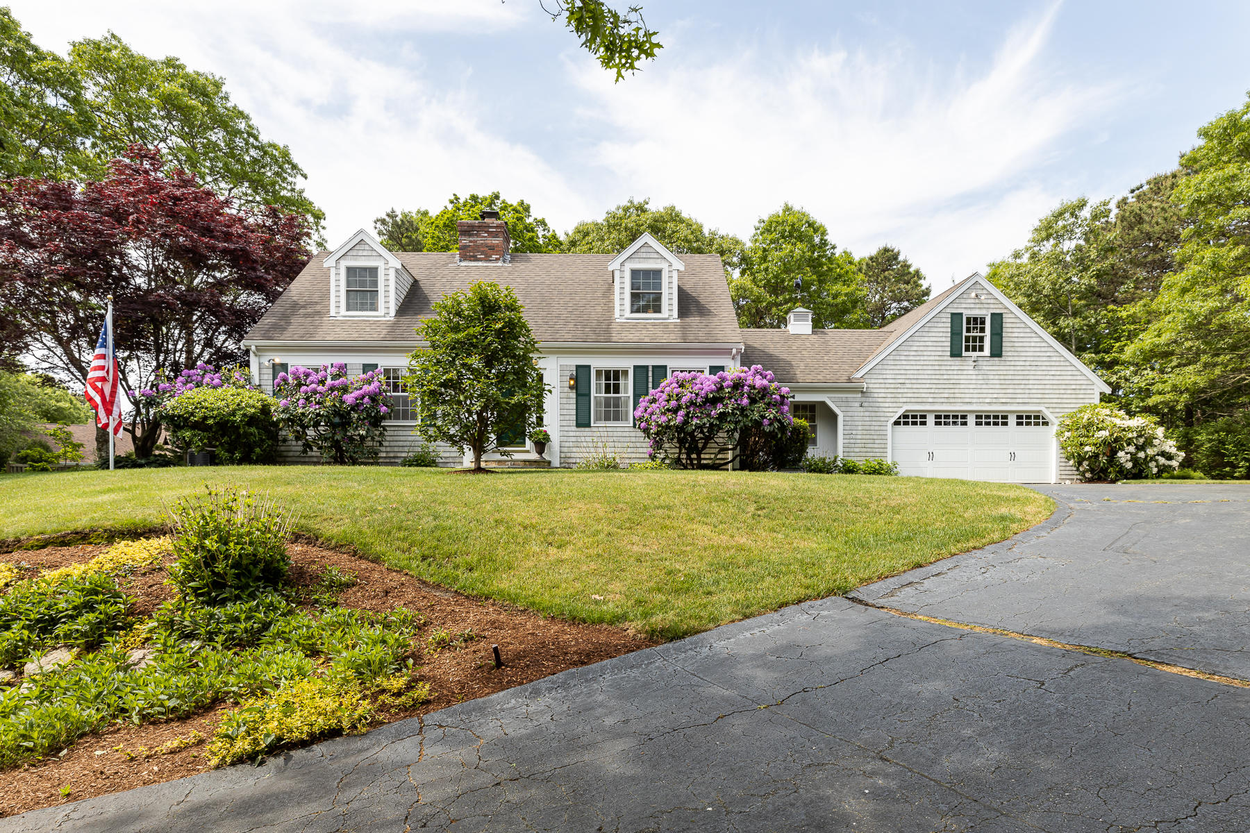 a view of a house with a yard and potted plants