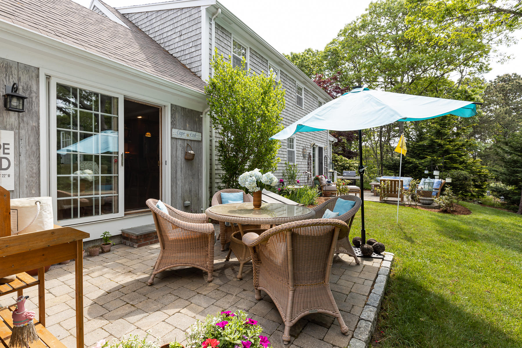 1122 Old Post Road Cotuit, MA 02635 - Photo 20 of 32 a view of a patio with table and chairs under an umbrella