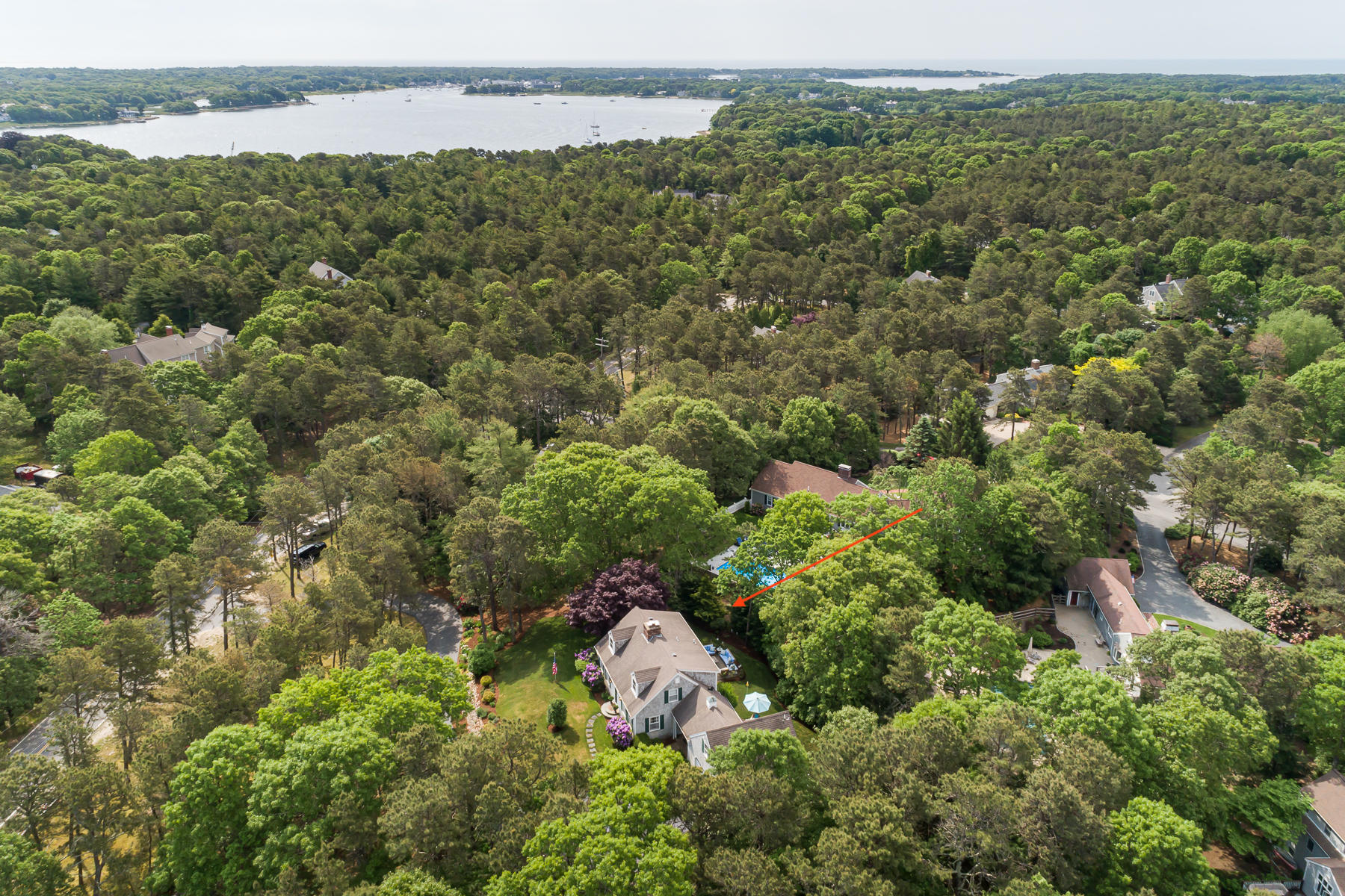 1122 Old Post Road Cotuit, MA 02635 - Photo 4 of 32 a view of a lake with a house in the background