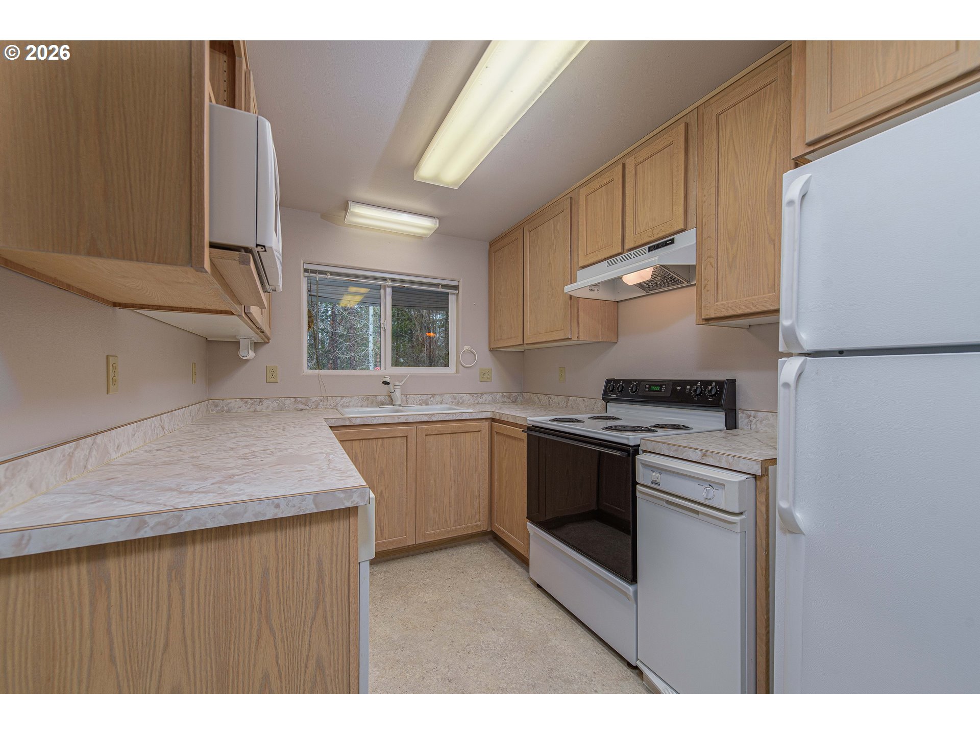 138722 Rhododendron Street Gilchrist, OR 97737 - Photo 18 of 27 a kitchen with kitchen island a stove a sink and a refrigerator