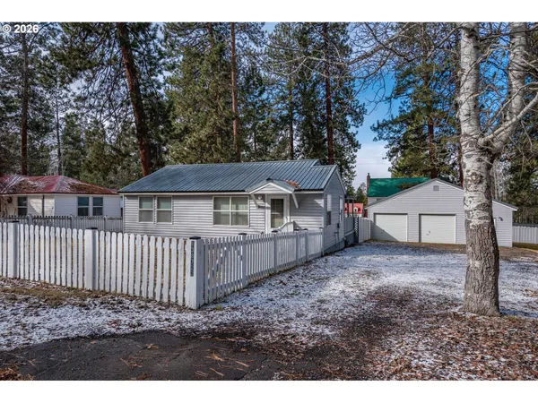 a view of a backyard with a cabin and wooden fence